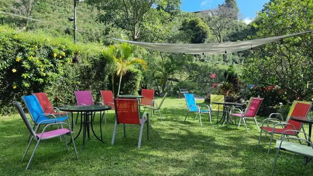 Panama, Boquete town, colorful tables and chairs in the tropical garden on a sunny day