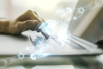 Creative concept of robotics technology with globe sketch and hands typing on laptop on background. Robot development and automation concept. Multiexposure