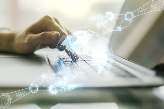 Creative concept of robotics technology with globe sketch and hands typing on laptop on background. Robot development and automation concept. Multiexposure