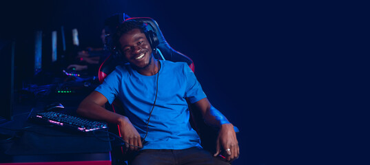 Banner portrait happy African American gamer plays online video games in computer club at championship multiplayer PvP, copy space for text