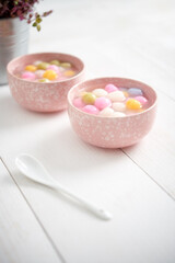Colourful tangyuan (tang yuan, glutinous rice dumpling balls) in pink bowl on white background for Winter solstice festival food.