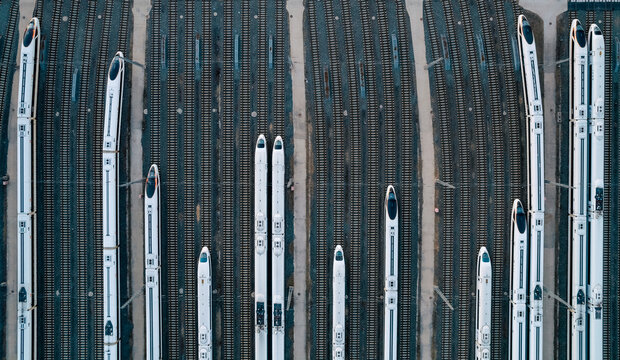 Aerial shots of multiple high-speed trains parked on railway tracks