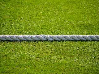 White rope divides green lawn
