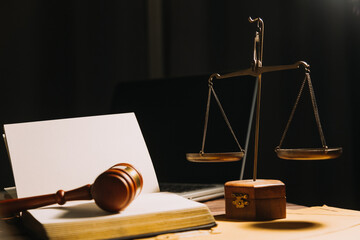 Business and lawyers discussing contract papers with brass scale on desk in office. Law, legal services, advice, justice and law concept picture with film grain effect