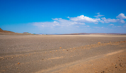 Fototapeta na wymiar A dirt road in the panoramic desert landscapes of Loiyangalani District in Turkana, Kenya