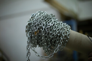 Steel chain wound on stick. High strength steel chain. Industrial item. Links of silver color.