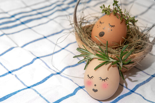 Easter egg with cute face in green plant wreath. Sleepy easter egg - Home crafts happy haster concept.