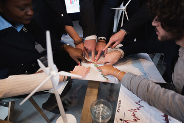 Top view desk with paperwork. Unrecognizable multiracial teamwork pointing at the same direction in a paperwork.