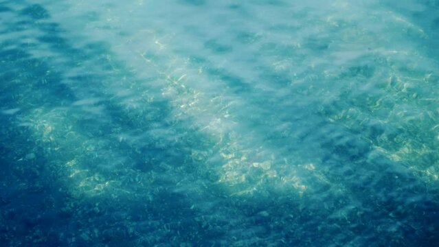 海岸・きらめき・日差し　太陽の光でキラキラと輝く海の水面と穏やかな波　春・夏・海水浴・夏休み・観光・旅行・釣りのイメージ背景