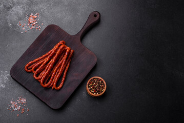 Delicious thin smoked meat sausages with spices and herbs
