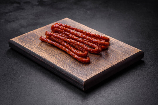 Delicious thin smoked meat sausages with spices and herbs