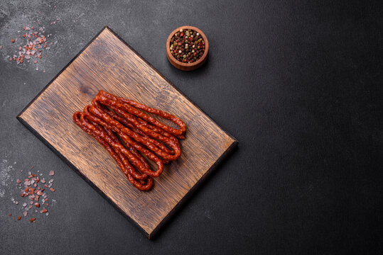 Delicious thin smoked meat sausages with spices and herbs