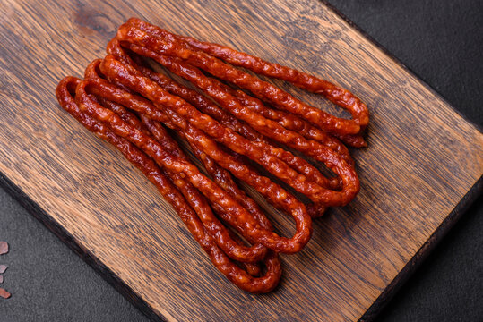 Delicious thin smoked meat sausages with spices and herbs