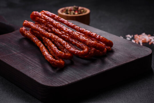Delicious thin smoked meat sausages with spices and herbs
