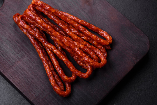 Delicious thin smoked meat sausages with spices and herbs