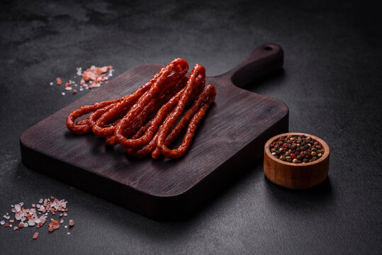 Delicious thin smoked meat sausages with spices and herbs