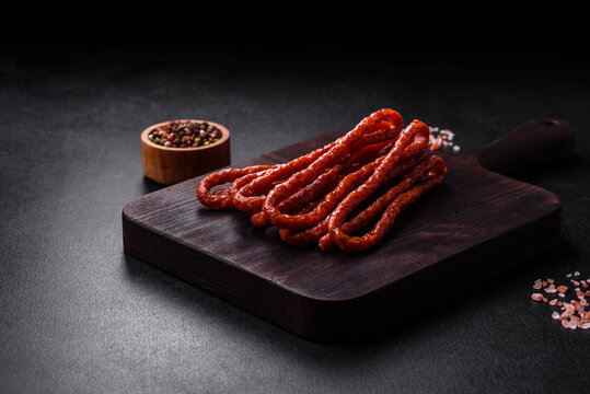 Delicious thin smoked meat sausages with spices and herbs