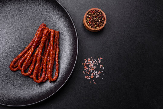 Delicious thin smoked meat sausages with spices and herbs