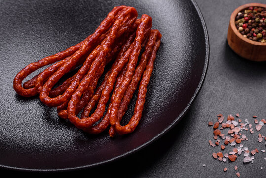 Delicious thin smoked meat sausages with spices and herbs