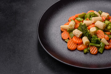 A mixture of vegetables: carrots, small heads of corn, asparagus beans steamed