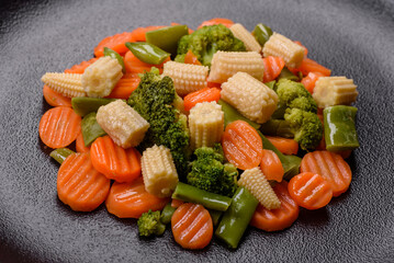 A mixture of vegetables: carrots, small heads of corn, asparagus beans steamed