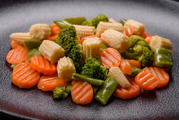 A mixture of vegetables: carrots, small heads of corn, asparagus beans steamed