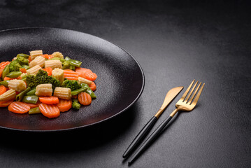 A mixture of vegetables: carrots, small heads of corn, asparagus beans steamed