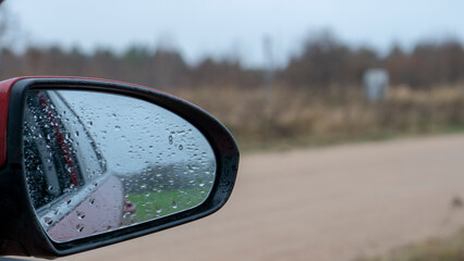 Car mirror on the background of the road