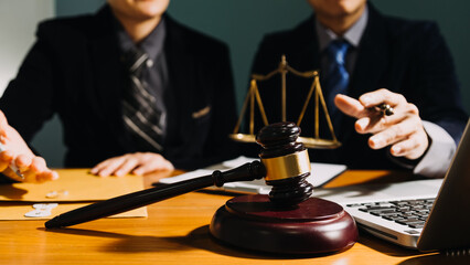 Business and lawyers discussing contract papers with brass scale on desk in office. Law, legal services, advice, justice and law concept picture with film grain effect