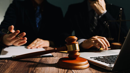 Business and lawyers discussing contract papers with brass scale on desk in office. Law, legal services, advice, justice and law concept picture with film grain effect