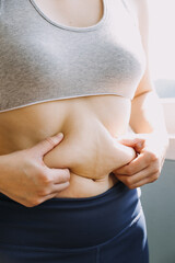 Beautiful fat woman with tape measure She uses her hand to squeeze the excess fat that is isolated on a white background. She wants to lose weight, the concept of surgery and break down fat under the