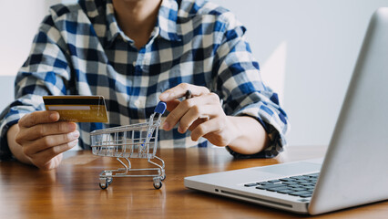 Hands holding credit card and using laptop. Online shopping