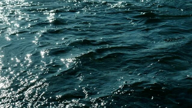波・入り江太陽の光でキラキラと輝く海の水面と穏やかな波　春・夏・海水浴・夏休み・観光・旅行・釣りのイメージ背景