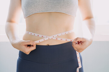 Beautiful fat woman with tape measure She uses her hand to squeeze the excess fat that is isolated on a white background. She wants to lose weight, the concept of surgery and break down fat under the