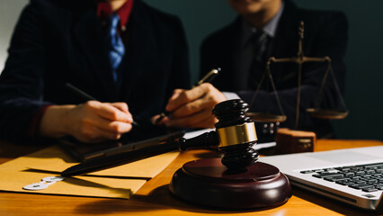 Business and lawyers discussing contract papers with brass scale on desk in office. Law, legal services, advice, justice and law concept picture with film grain effect
