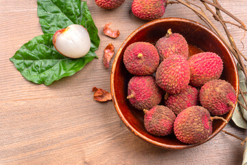 Fresh lychee with leaves isolated on wooden background.