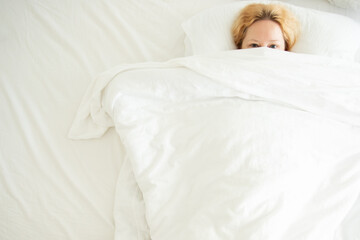 woman hiding under a blanket, fear, stress and fright