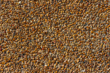 Small colored stones on the surface of the wall.