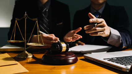 Business and lawyers discussing contract papers with brass scale on desk in office. Law, legal services, advice, justice and law concept picture with film grain effect