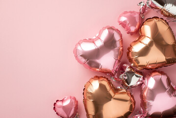 Valentine's Day concept. Top view photo of heart shaped pink silver and golden balloons on isolated pastel pink background with empty space