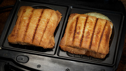 croque monsieur cuisant dans un appareil à croque-monsieur