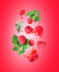 Whole and sliced raspberries with juice splashes in the air on a red background