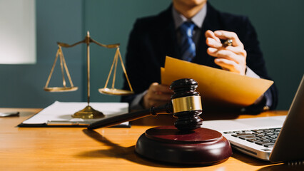 Business and lawyers discussing contract papers with brass scale on desk in office. Law, legal services, advice, justice and law concept picture with film grain effect
