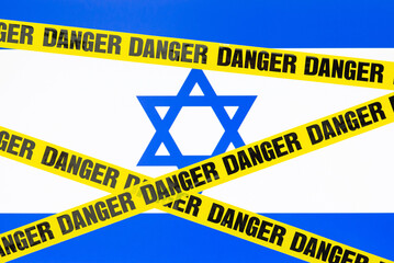Flag of Israel with danger tape on the foreground. Concept of dangerous travel to Israel, new wave...