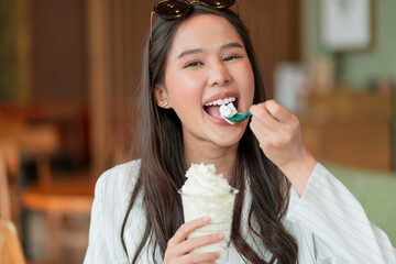 happiness joyful asian young adult female woman teasing yummy smiling hand hold whipped cream in...