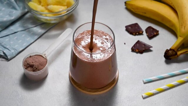 Protein chocolate shake with banana, protein powder and cocoa. Healthy fitness drink.