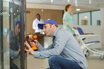 man repairing vending machine using screwdriver in hospital