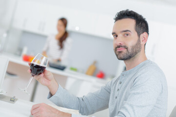Man sat in kitchen with glass of red wine