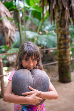 Young girl embracing Coco De Mer along a beautiful tropical trail, Vallee de Mai