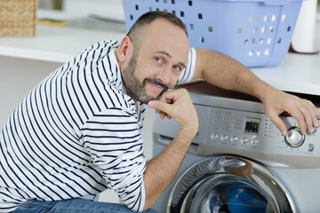 Obraz premium man setting programme on washing machine